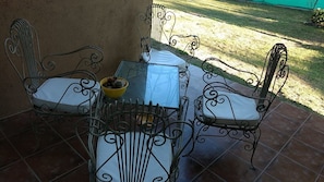 A patio with a glass table and four metal chairs with cushions. - Aires de Ambar (Merlo)