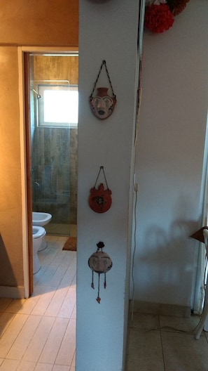 A bathroom with a shower, toilet, and a wall-mounted towel rack. - Aires de Ambar (Merlo)