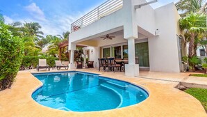 A modern house with a swimming pool, outdoor seating, and a covered patio. - Pura Vida by NAS (Playa del Carmen)