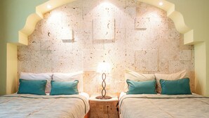 A twin room with two beds, a marble headboard, and a small bedside table with a lamp. - Pura Vida by NAS (Playa del Carmen)