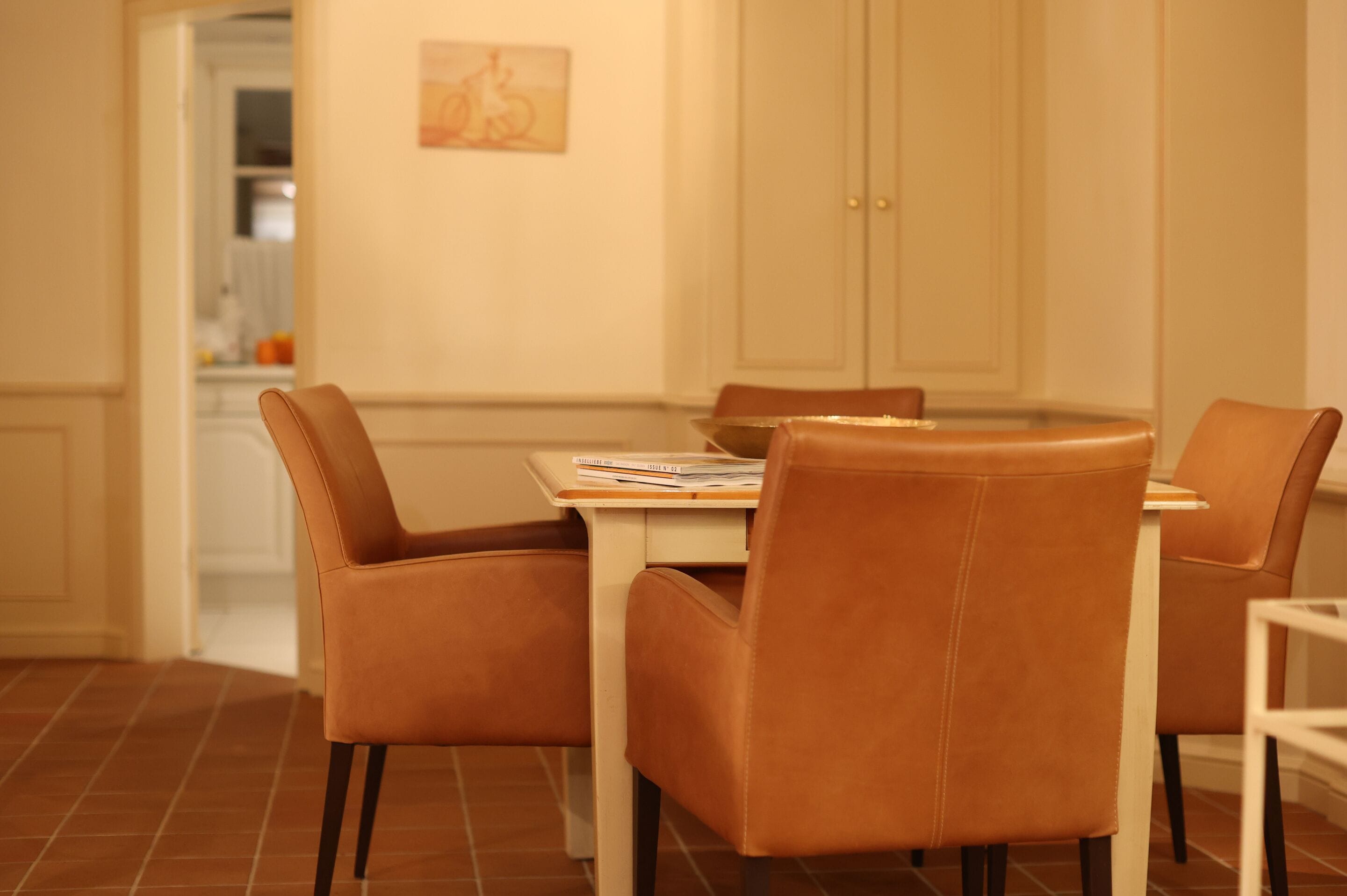 A dining area with a table and four brown chairs.