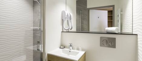 Une salle de bain moderne avec une douche à parois de verre, un meuble-lavabo en bois et un grand miroir.