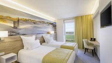 A hotel room with two beds, a desk, a chair, a TV, and a painting of a landscape.