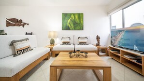 A modern living room with a wooden coffee table, two white sofas, a large flat-screen TV, and a green leaf painting on the wall. - Quintas Pakal 21 by NAS (Playa del Carmen)