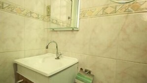 A bathroom with a sink, mirror, and towel rack.
