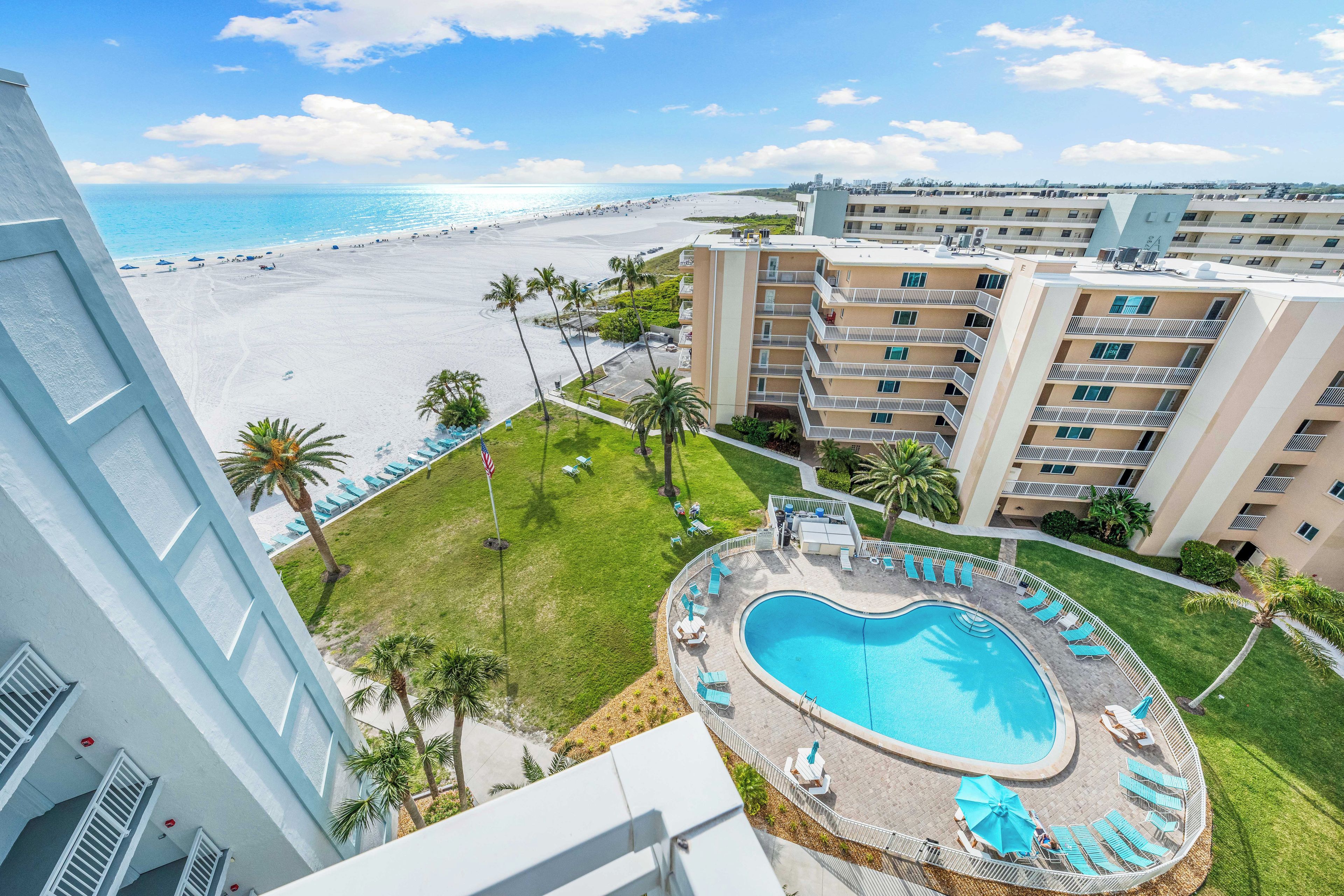 Un hôtel doté d'une piscine, offrant une vue sur la plage et comprenant plusieurs balcons.