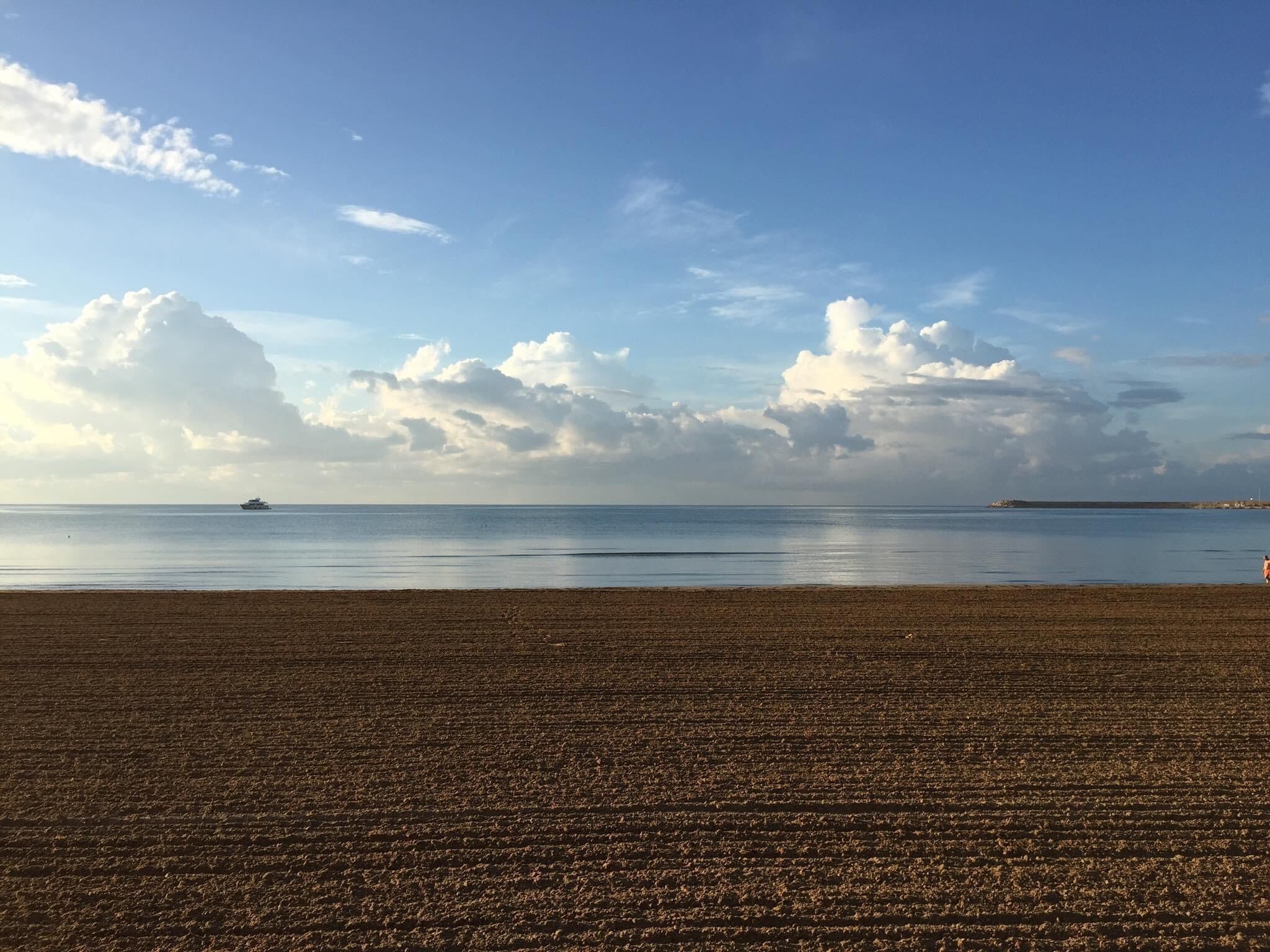 A beach with a clear sky and calm sea.