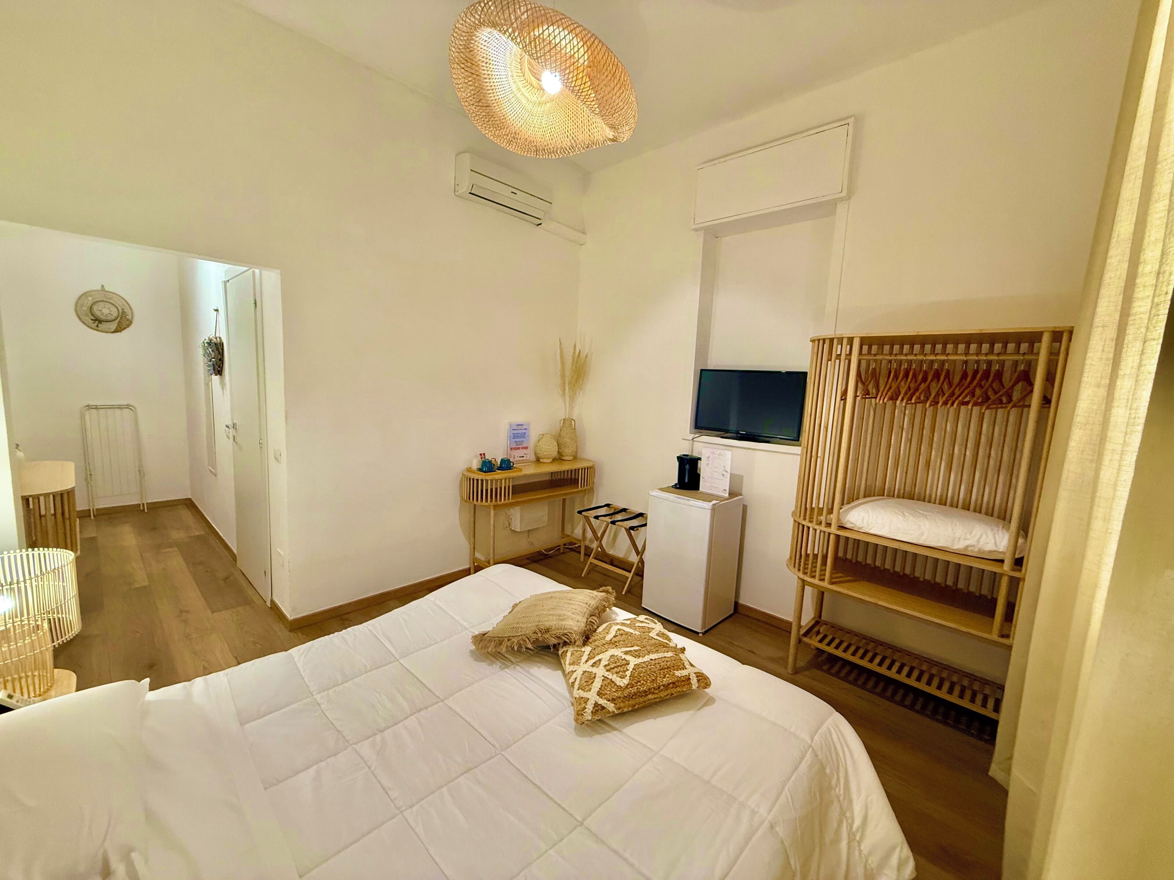 Un dormitorio con cama, televisión, escritorio y armario.