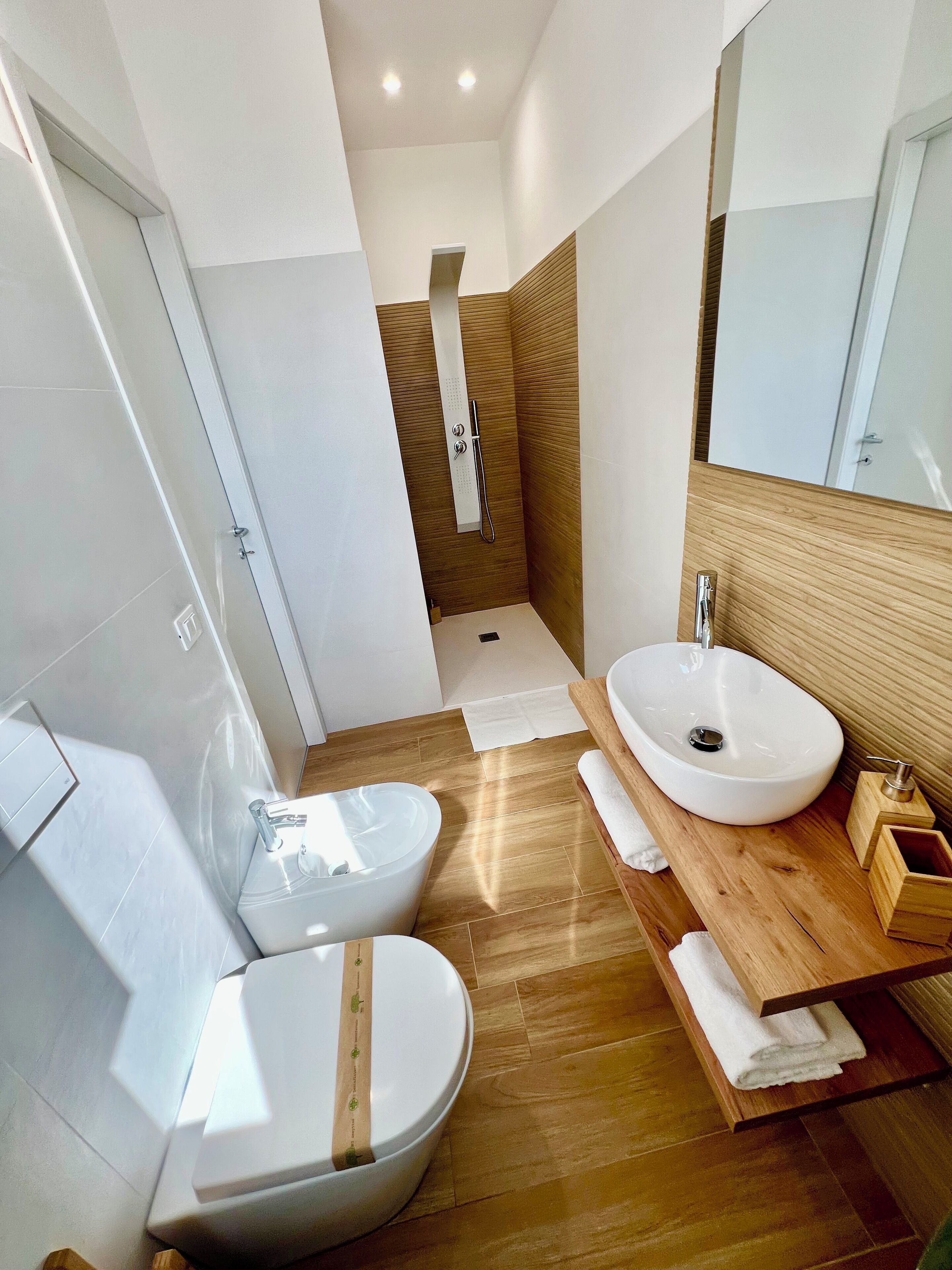 A modern bathroom with a freestanding bathtub, a double sink vanity, and a walk-in shower.