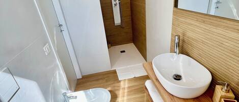 A modern bathroom with a freestanding bathtub, a double sink vanity, and a walk-in shower.