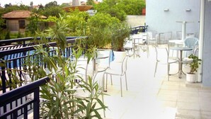 Una terrazza sul tetto con posti a sedere all'aperto e piante in vaso.