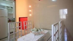 A room with a bed, a small table, and a red cabinet. - GoHouse Djalma 401 A (Rio de Janeiro)