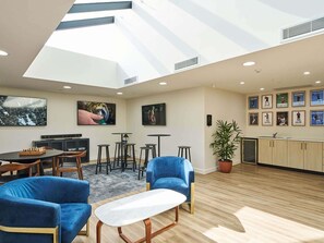 A modern interior with a skylight, a dining area, a kitchen, and sports memorabilia on the walls.