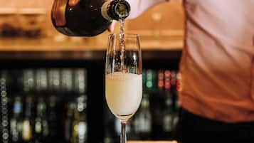 A bartender pouring a drink into a glass.