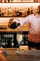 Un bartender sirviendo una bebida en un vaso.