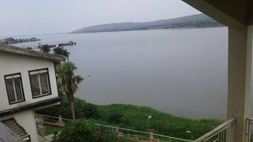 A view of a calm lake from a balcony with a house in the foreground.
