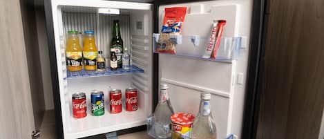 An open refrigerator stocked with beverages and snacks.