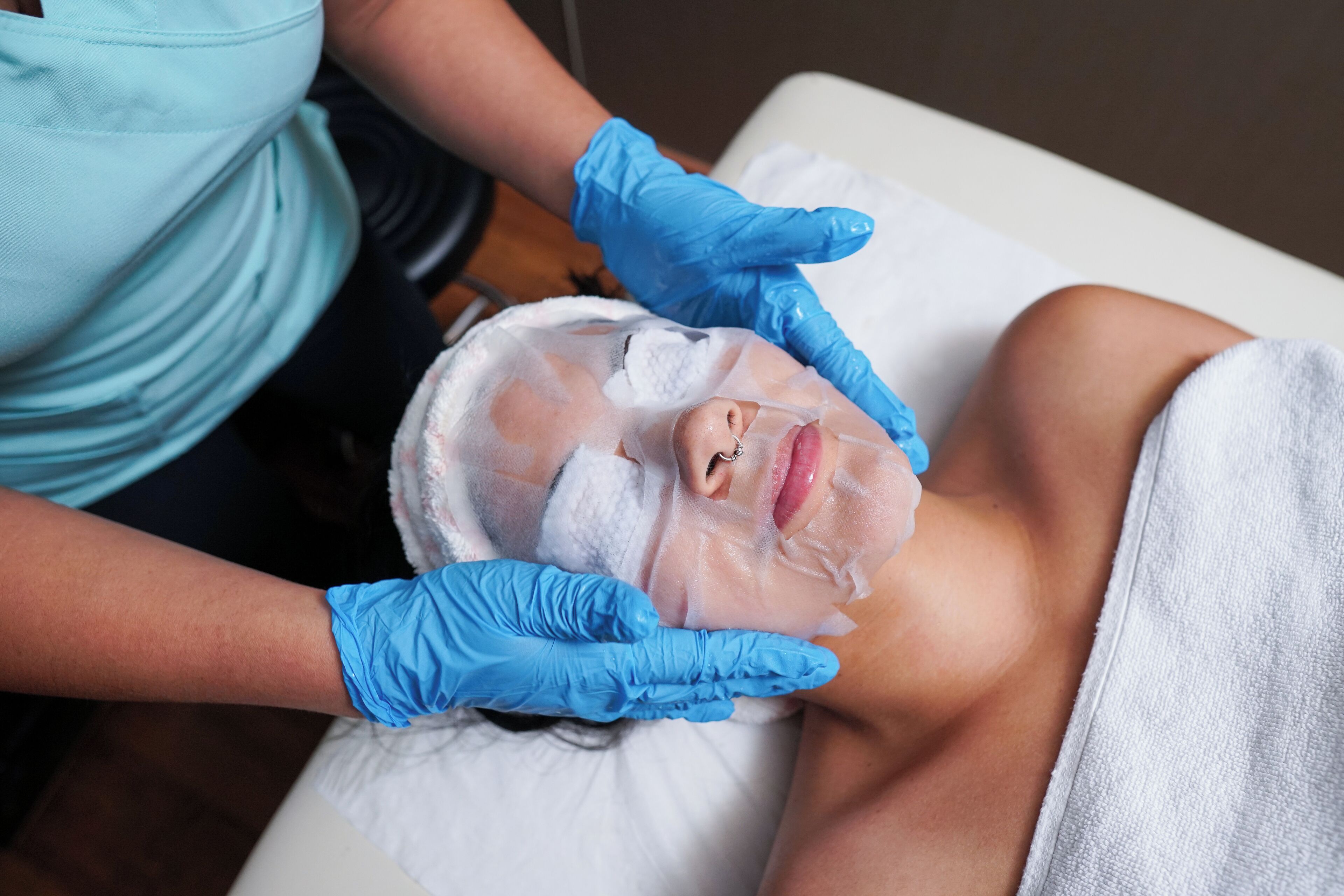 A person receiving a facial treatment with a facial mask.