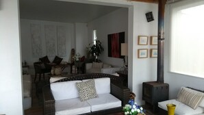A living room with a sofa, a dining table, and a fireplace. - Casa Av. Costanera sn Sector Casino (Coquimbo)