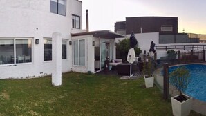 A modern house with a swimming pool, a patio, and a small garden. - Casa Av. Costanera sn Sector Casino (Coquimbo)