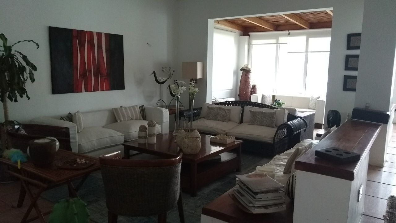 Ein Wohnzimmer mit einer Couch, einem Couchtisch und Dekoration. Ein Fenster bietet einen Ausblick nach draußen.