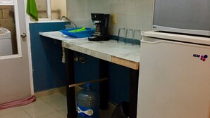 A compact kitchen with white cabinets, a sink, a coffee maker, and a refrigerator. - Apartamento PlayaDelCarmen 627 by Sinbad (Playa del Carmen)
