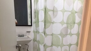 A small bathroom with a toilet, sink, and mirror. - Apartamento PlayaDelCarmen 627 by Sinbad (Playa del Carmen)
