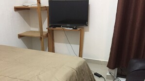 A bedroom with a bed, a desk with a laptop, and a chair. - Apartamento PlayaDelCarmen 627 by Sinbad (Playa del Carmen)