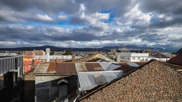 Vista de un paisaje urbano con edificios, una cordillera y un cielo nublado.
