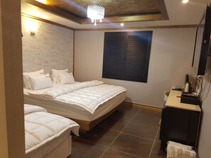 A bedroom with a bed, a bedside table, a TV, and a window with shutters. - Business Hotel (Busan)
