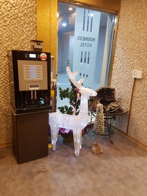 A coffee machine, a decorative chair, and a sign for a business hotel. - Business Hotel (Busan)