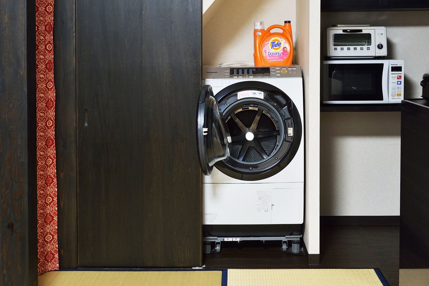 A compact laundry area with a washing machine, a dryer, and a microwave.