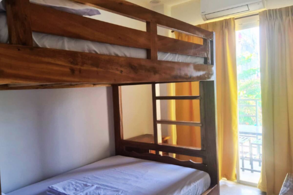 Habitación con literas, ventana y cortinas.