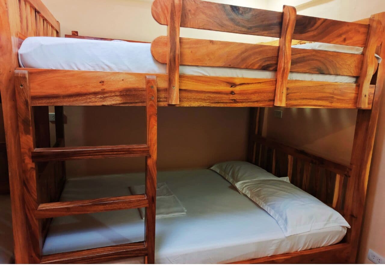 Een stapelbed met houten frame en een ladder.