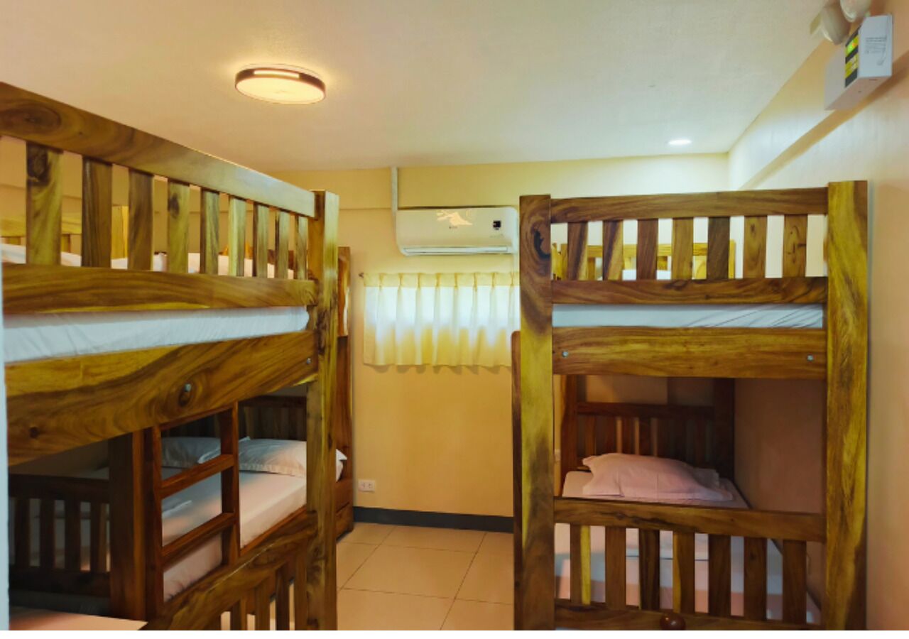 Una habitación con literas, un radiador y una ventana con cortinas.