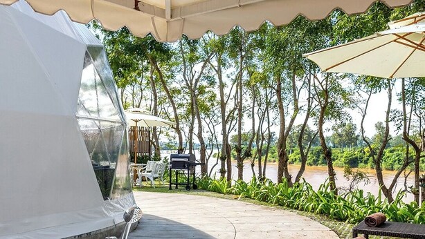 A spa area with a large bathtub, a grill, and outdoor seating. - Bansaeo Garden and Resort (Chiang Saen)