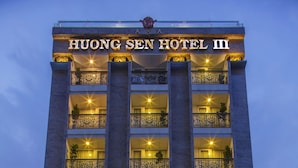 A multi-story hotel with a prominent sign reading "HUONG SEN HOTEL II". The building features ornate balconies with metal railings and potted plants. - Huong Sen Annex Hotel (Ho Chi Minh City)