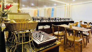 A buffet setup with wicker baskets, a knife on a cutting board, and a variety of food containers. - Huong Sen Annex Hotel (Ho Chi Minh City)