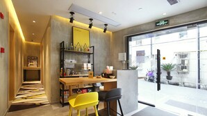 Un intérieur moderne avec un coin bar, des chaises jaunes et une vue sur la rue.