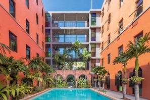 Una piscina al aire libre, sillones reclinables de piscina