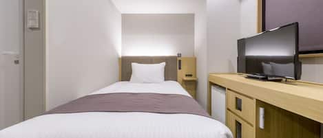 A hotel room with a bed, a desk with a television, and a small cabinet.