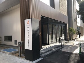 A modern building with a sign for Almont Inn, featuring a glass entrance and a ramp for accessibility. - Almont Inn Shonan Fujisawa (Fujisawa)
