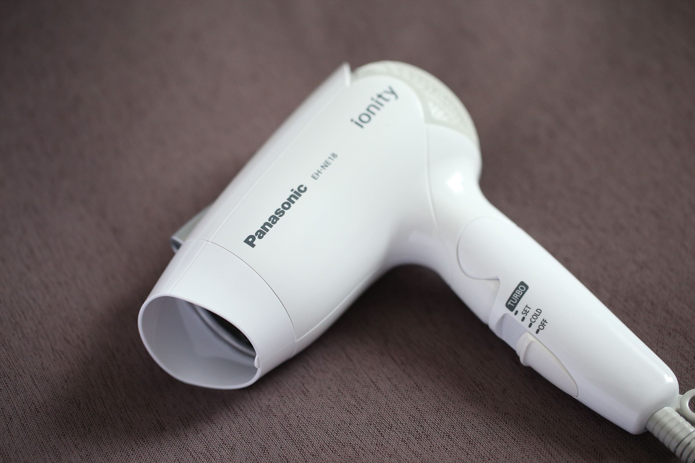 Un secador de pelo Panasonic Ionity con cuerpo blanco y panel de control en el mango.