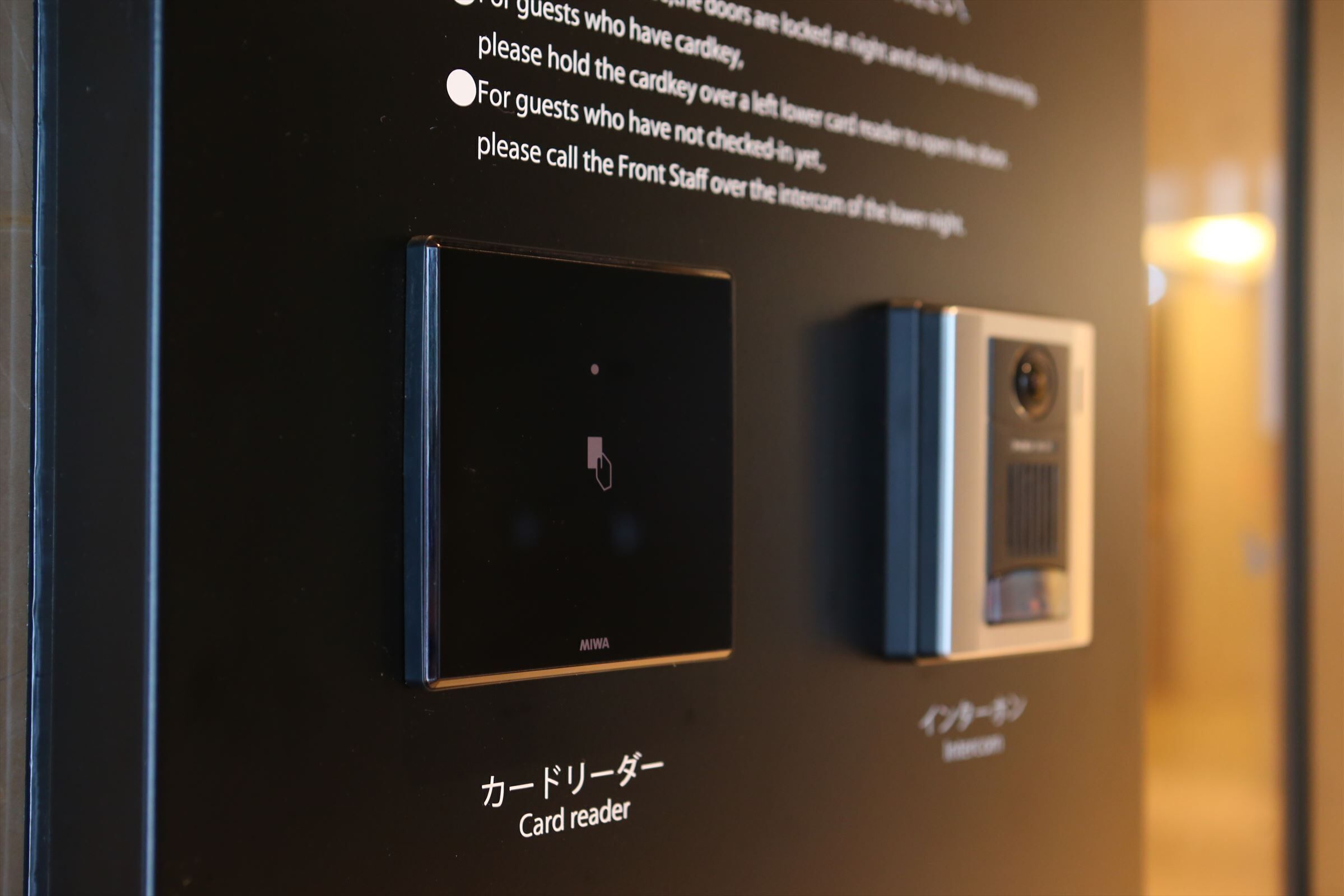 A card reader and a security camera mounted on a wall.