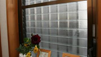 Una ventana con marco de madera, un panel de vidrio esmerilado y un estante debajo.