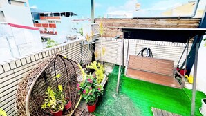A rooftop garden with potted plants, a wooden deck, and a pergola structure. - E-Phone hotel (Ji'an)