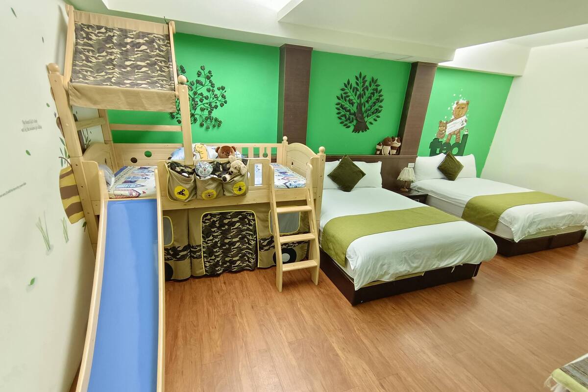 A children's room with bunk beds, a desk, and a play area.