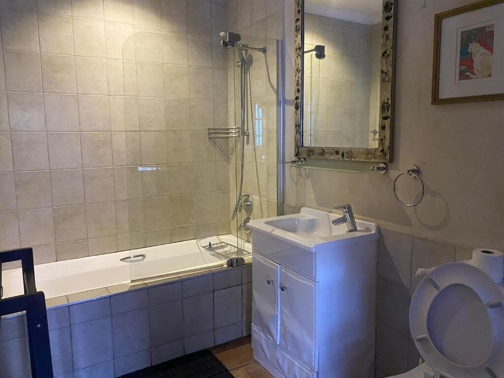 Un baño con bañera, lavamanos, inodoro y ducha.