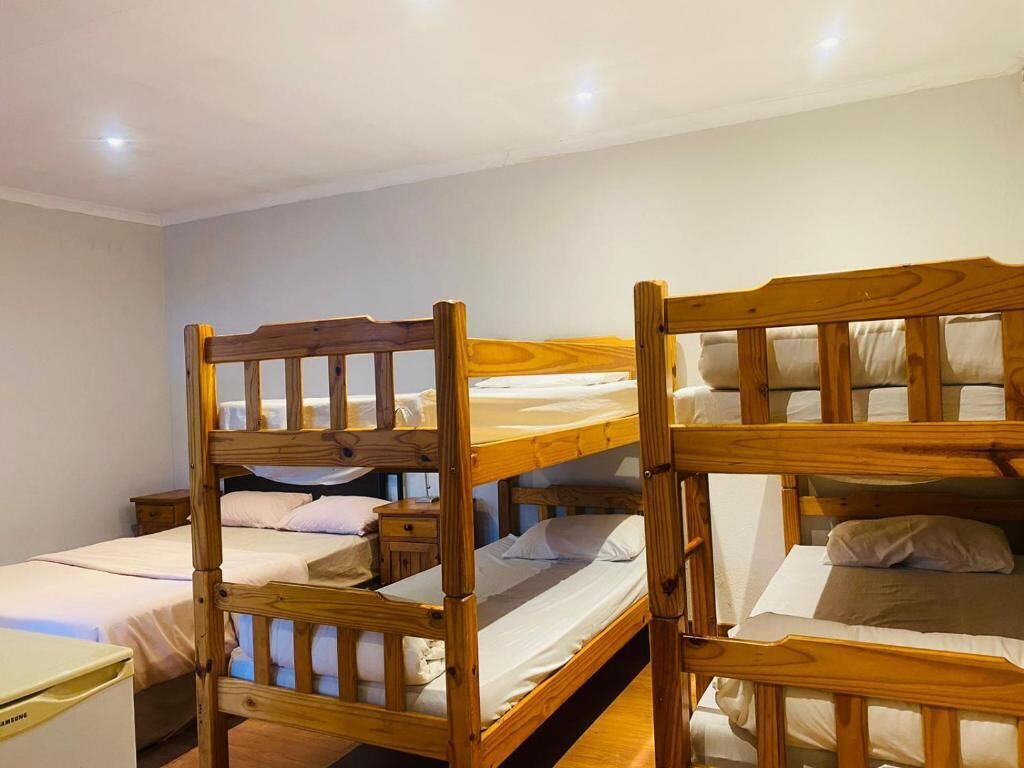 Una habitación con literas y una mesita de noche pequeña.