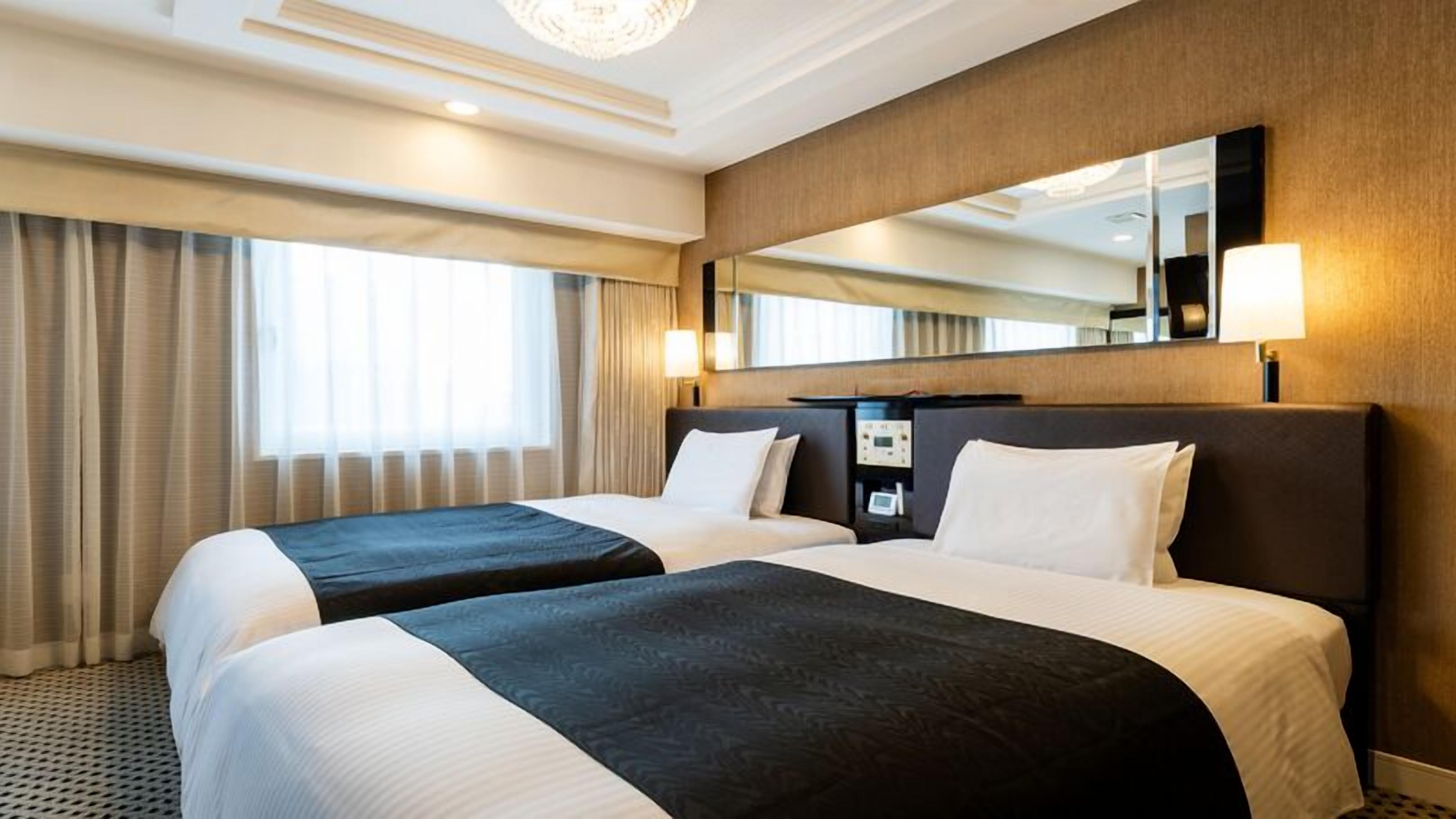 Ein Hotelzimmer mit zwei Betten, einem großen Spiegel und einer Bedienkonsole.